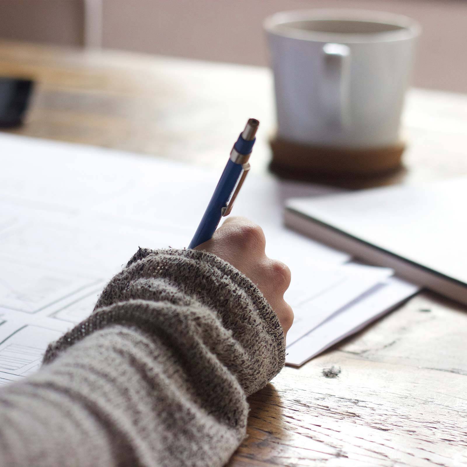 Person Writing at a Desk