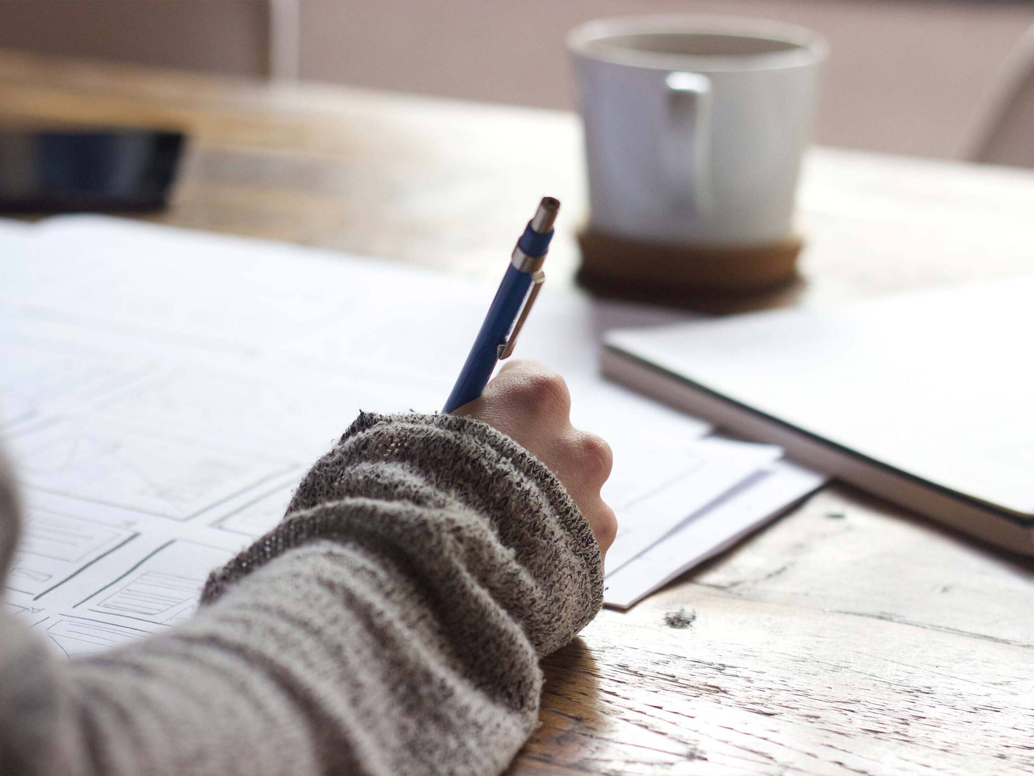 Person Writing at a Desk